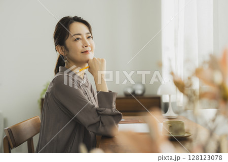 自宅でデスクに向かう女性　 128123078