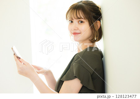 スマホを持つ若い女性 128123477