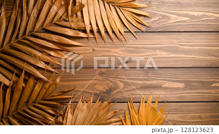 パームリーフのように広がった紅葉の葉を木目風背景にレイヤーしたテクスチャ 128123623