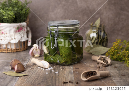 Half-sour dill pickle (quick pickled cucumbers) in a jar with seasonings, spices and herbs. Homemade seasonal preparations. Traditional canning of vegetables. Selective focus, close-up. Half-sour dill pickle (quick pickled cucumbers) in a jar with seasonings, spices and herbs. Homemade seasonal preparations. Traditional canning of vegetables. Selective focus, close-up. 128123925