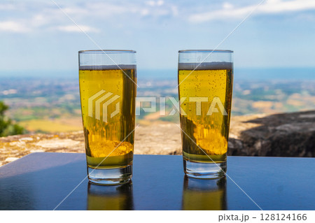 Two glasses of beer on a table with a view of San Marino Two glasses of beer on a table with a view of San Marino 128124166