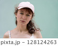 A Casual Portrait Featuring a Woman Wearing a Pink Cap Set Against a Solid and Simple Background A Casual Portrait Featuring a Woman Wearing a Pink Cap Set Against a Solid and Simple Background 128124263