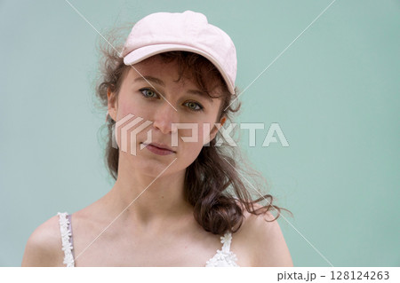 A Casual Portrait Featuring a Woman Wearing a Pink Cap Set Against a Solid and Simple Background A Casual Portrait Featuring a Woman Wearing a Pink Cap Set Against a Solid and Simple Background 128124263