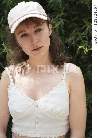 Stylish and Chic Summer Outfit Featuring a Cap Surrounded by a Natural Beautiful Setting Stylish and Chic Summer Outfit Featuring a Cap Surrounded by a Natural Beautiful Setting 128124267