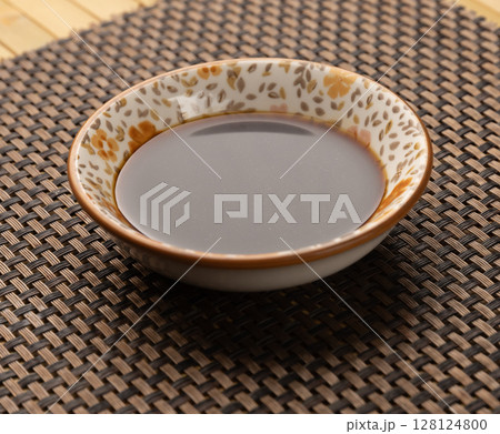 Small bowl containing soy sauce 128124800