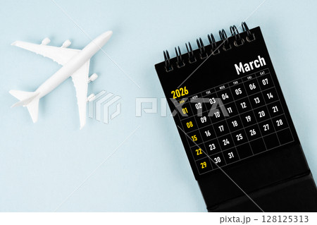 March 2026 black calendar and airplane toy on blue color background. March 2026 black calendar and airplane toy on blue color background. 128125313