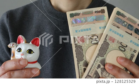招き猫のご利益で大金を手に入れた人物をイメージ 招き猫のご利益で大金を手に入れた人物をイメージ 128125329