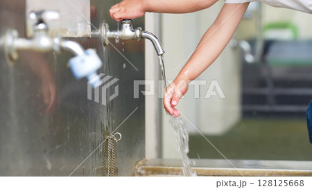 水道で手を洗う女の子 128125668