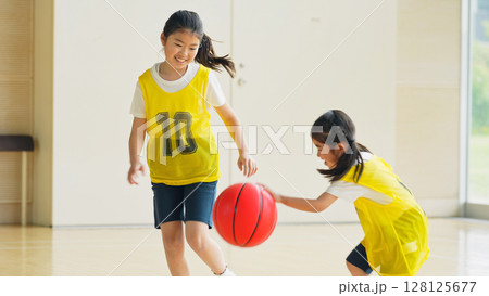 体育館でバスケットボールをする子供たち 128125677