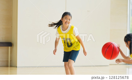 体育館でバスケットボールをする子供たち 128125678