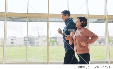 室内でランニングするミドルエイジカップル 128125694