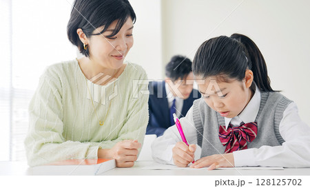 女の子に指導する女性教師 128125702