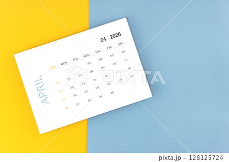 April 2026 calendar page on blue color background, Position with copy space. April 2026 calendar page on blue color background, Position with copy space. 128125724