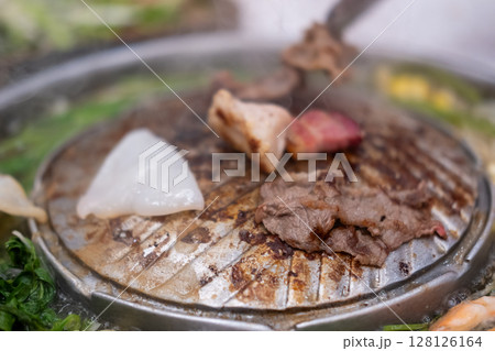 Thai style pork, bacon and seafood barbecue with vegetable soup 128126164