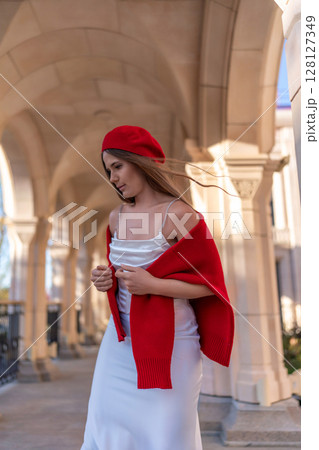 Beret Shawl Dress: Woman poses under arches in daytime for photoshoot outdoors. 128127349