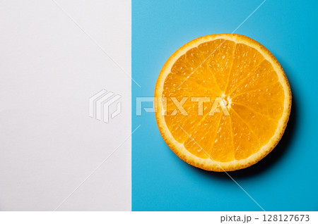 Whole orange slice, on blue and white background. Top view. Flat lay, mockup for text Whole orange slice, on blue and white background. Top view. Flat lay, mockup for text 128127673