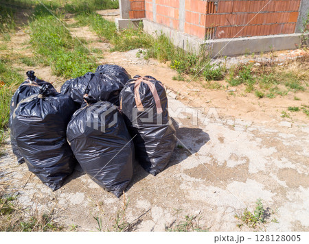 Garbage bags near building under renovation 128128005