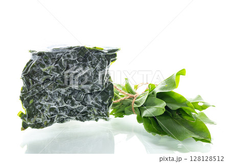 Vacuum packaging with sorrel and fresh greens next to it on a white background Vacuum packaging with sorrel and fresh greens next to it on a white background 128128512