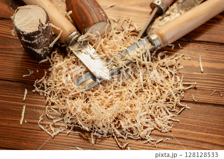 Close up of wood carving with sawdust on wooden table Close up of wood carving with sawdust on wooden table 128128533