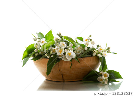 jasmine flowers with foliage in wooden bowl isolated on white background jasmine flowers with foliage in wooden bowl isolated on white background 128128537