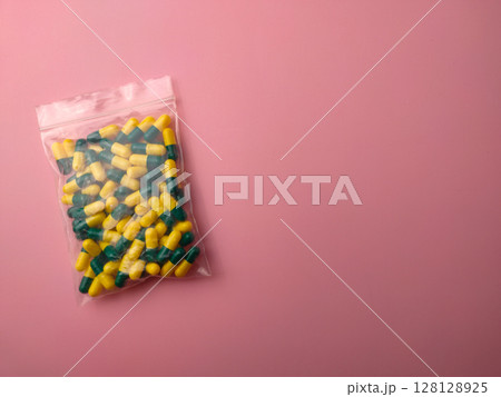 Top view of a medicine pill package on a pink background with copy space. 128128925