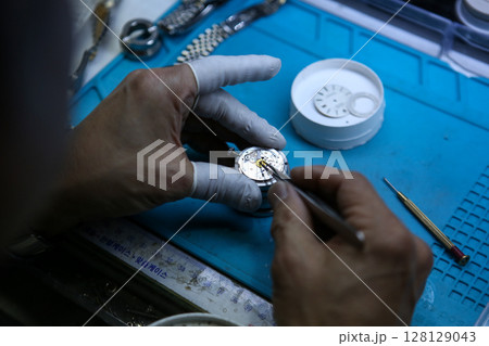 Repairing a wristwatch. Watch repair Repairing a wristwatch. Watch repair 128129043