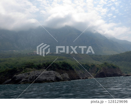 Rocky Coast of Adriatic Sea in Montenegro With Gentle Waves and Cloudy Sky Rocky Coast of Adriatic Sea in Montenegro With Gentle Waves and Cloudy Sky 128129696