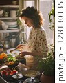 Focused on fresh and healthy eating, a woman prepares ingredients for a nutritious meal in her airy home kitchen. 128130135