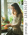 Comfortably dressed, a woman prepares a fresh morning meal in a kitchen bathed in natural light. 128130137