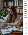 Surrounded by books and soft silence, a young student types with intent, studying in a calm library setting. 128130139