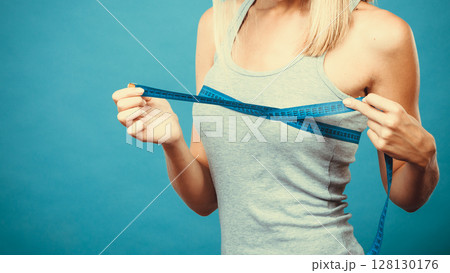 Fitness girl measuring her breasts Fitness girl measuring her breasts 128130176