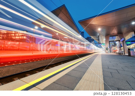 High speed train in motion on the railway station at night 128130453