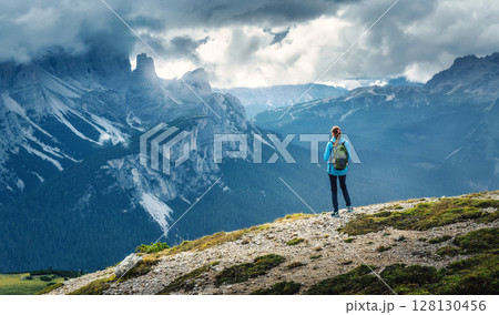 Female hiker admiring Dolomites mountain landscape in summer day Female hiker admiring Dolomites mountain landscape in summer day 128130456