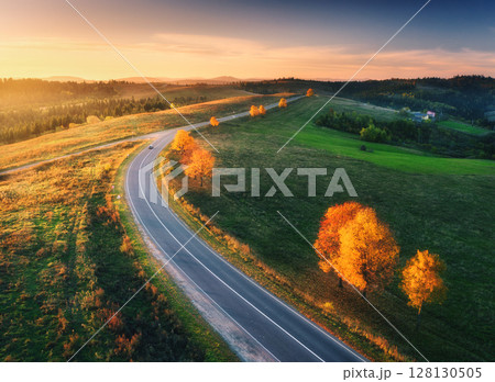 Aerial view of winding road in autumn forest at sunset 128130505