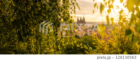 Sunrise paints the sky above Prague Castle, illuminating the historic architecture. Lush greenery frames the view, creating a serene and enchanting atmosphere in the heart of the city. Sunrise paints the sky above Prague Castle, illuminating the historic architecture. Lush greenery frames the view, creating a serene and enchanting atmosphere in the heart of the city. 128130563