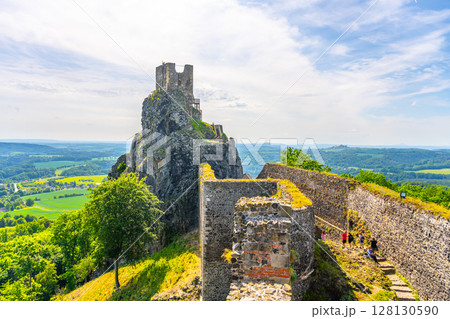 Visitors explore the majestic Baba Tower amidst the ancient Trosky Castle ruins. Set in Bohemian Paradise, the site offers stunning views of the surrounding landscape on a clear day. Visitors explore the majestic Baba Tower amidst the ancient Trosky Castle ruins. Set in Bohemian Paradise, the site offers stunning views of the surrounding landscape on a clear day. 128130590