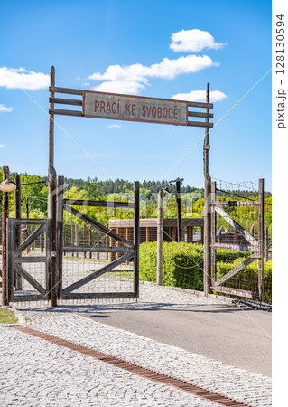 The entrance gate to the former Vojna prison complex in Lesetice, Czechia, features a rustic wooden structure and a sign, symbolizing a historical transition. The entrance gate to the former Vojna prison complex in Lesetice, Czechia, features a rustic wooden structure and a sign, symbolizing a historical transition. 128130594
