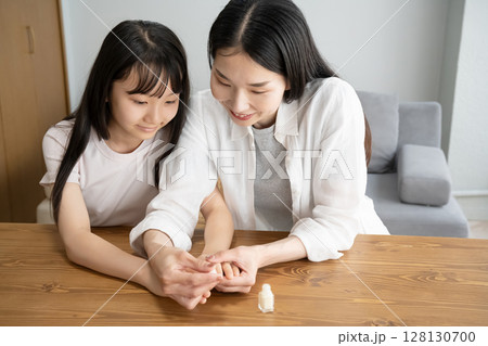 娘の爪にマニキュアを塗る母 娘の爪にマニキュアを塗る母 128130700