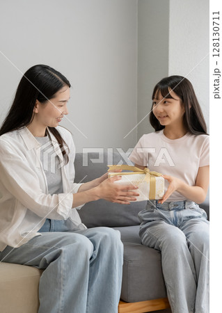 母にプレゼントを渡す娘 母にプレゼントを渡す娘 128130711