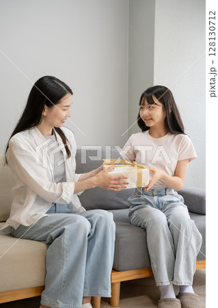母にプレゼントを渡す娘 128130712