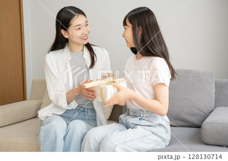 母にプレゼントを渡す娘 128130714