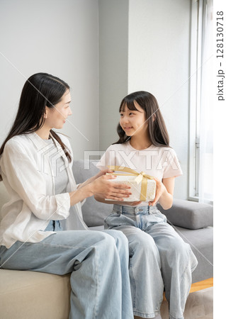 娘にプレゼントを渡す母 娘にプレゼントを渡す母 128130718