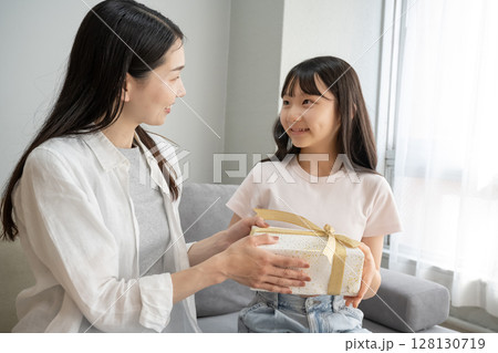 娘にプレゼントを渡す母 128130719