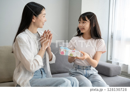 母にプレゼントを渡す娘 母にプレゼントを渡す娘 128130728