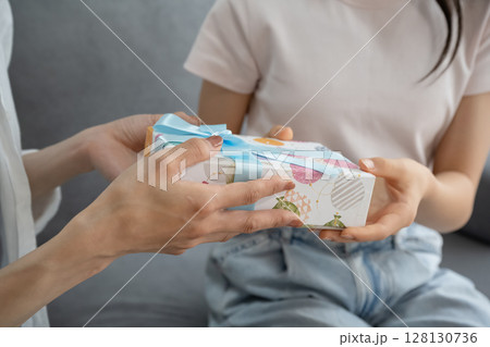 娘にプレゼントを渡す母 娘にプレゼントを渡す母 128130736