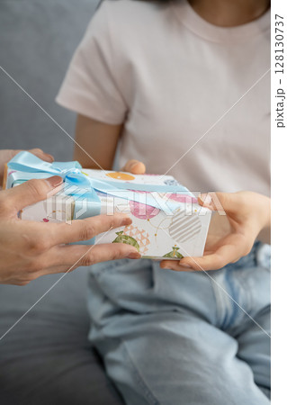 娘にプレゼントを渡す母 娘にプレゼントを渡す母 128130737