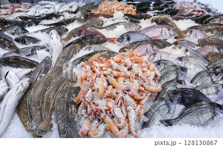 Vibrant collection of fresh seafood displayed at Greek fish market, showcasing variety of fish and shellfish on ice, attracting customers seeking quality ingredients. 128130867