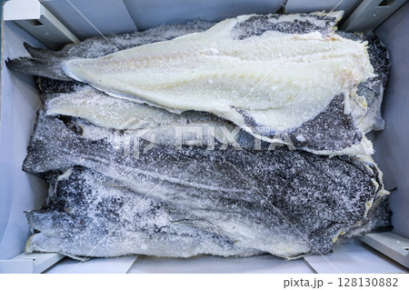 Salt cod or bakaliaros or hake, Merluccius merluccius in Greek fish market. Horizontal. Top view. 128130882