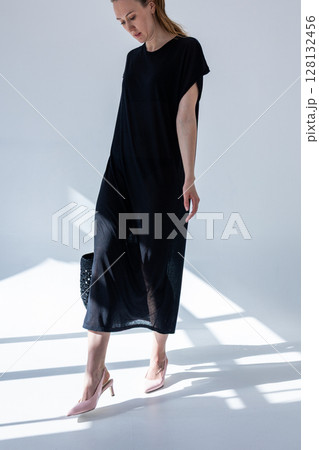 Beautiful woman holding fashionable black woven bag. Fashion and luxury accessories. Vertical photo. High quality photo Beautiful woman holding fashionable black woven bag. Fashion and luxury accessories. Vertical photo. High quality photo 128132456