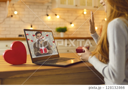 Young couple video calling each other during quarantine and showing Valentine gifts they prepared Young couple video calling each other during quarantine and showing Valentine gifts they prepared 128132866